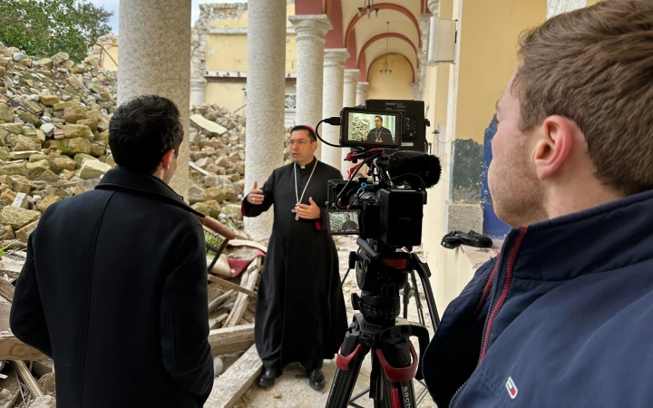 Weihbischof Antuan Ilgit SJ spricht im EWTN-Interview mit Colm Flynn (links) und Patrick Leonard (rechts) im inneren der zerstörten Kathedrale von Iskenderun.